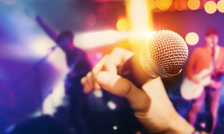 Singer holding mic while performing live with band in tips to promote your music on Instagram